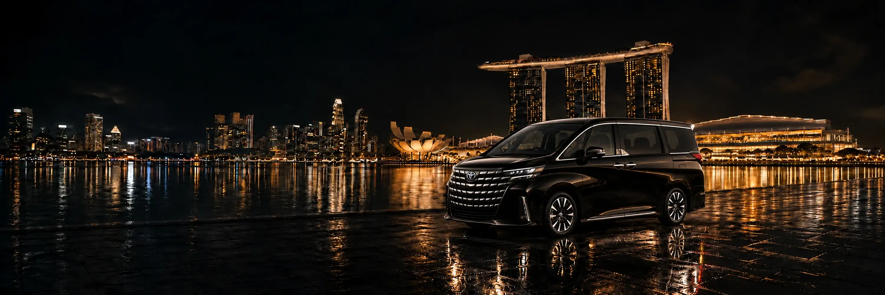 A black chauffeur MPV on the Marina Bay waterfront at night